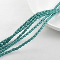 Macro detail of oval turquoise beads on white ceramic plate for DIY jewelry making - 4*6mm (Approx. 60pcs) / Peacock Green