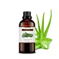 Organic 100ml aloe oil in brown glass bottle with fresh green aloe vera leaves - Aloe Oil 100ml