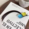 Cosplay hair clip with yellow and blue cubes and brown hair extension on a book - Ice Cube Dark Brown