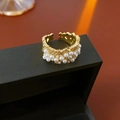Vista macro di anello aperto placcato oro con perle bianche su scatola nera - Oro-Bianco