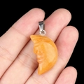 Engraved orange crescent moon stone pendant with silver clasp in hand view - Yellow Jade
