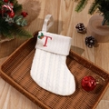 White knitted Christmas stocking with red embroidered letter T and green holly leaf detail - Letter T