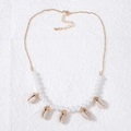 Detailed macro view of golden starfish and seashell pendants with white pearls on a necklace - Necklace F-Shell Pearl Combo