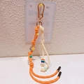 Détail d'un porte-clés en corde tressée avec fleur de soleil et perles colorées - 47.A08 Pendentif Fleur Orange Jaune