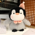 Cute plush penguin with pink party hat and bow tie sitting on a desktop - 20cm Penguin with Hat