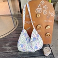 Sac fourre-tout en toile à fleurs bleues et violettes posé contre un panneau en bois - Floral Bleu