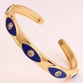 Close-up of golden C-shaped evil eye bracelet with blue enamel and clear zircon inlay - Dark Blue Enamel Style (SL99-2)