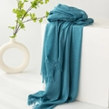 Teal pleated cotton linen scarf with fringe edges draped over a white cube - Lake Blue