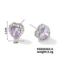 Macro view of heart-shaped silver earrings with purple center stone and white diamonds - Silver Frame / Purple
