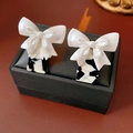 Detail of elegant bow earrings with monochrome textured square base on a jewelry box - Ear Clip Style(HE22031-2)