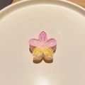 Detailed macro view of a pink and yellow gradient frangipani hair claw with glitter - Colorful Plumeria Pink Yellow