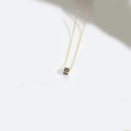 Minimalist square cube pendant necklace featuring a golden letter V on black enamel - Letter V