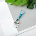 Sky blue braided rope keychain with silver metal clip on a decorative leaf background - Light Blue + Round Buckle + Triangle Spring Ring