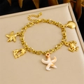Gouden schakelarmband met zee-bedeltjes zoals zeesterren op een zacht sieradenkussentje - Oceaan Thema Bedelstijl (B1724)