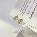 Close-up of gold pear cut cubic zirconia drop earrings on a minimalist stone base - Waterdrop Zircon Earrings