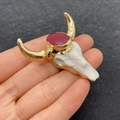 White bull head pendant with gold horns and red stone held in hand for size display - No. 11 - Red Stone