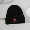 Close-up of a black knitted beanie featuring detailed red rose embroidery on a stone base - Embroidered Rose - Black