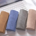 Chic nubuck leather sunglasses cases in four soft colors displayed on a laptop keyboard - Multicolor