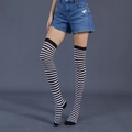 Detail of black and white striped over-knee socks with elastic knit on female model - Black & White Thin Stripes