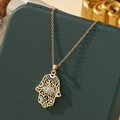 Collier main de Hamsa dorée avec pendentif œil bleu sur un coffret à bijoux vert foncé - A25 - Or