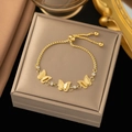 Detailed view of a gold-plated butterfly bracelet with white zircon on a gray jewelry box - Gold - Three Butterflies Single Zircon