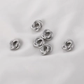 Primer plano de cinco cuentas de nudo plateadas para joyería DIY en tela blanca - 1 Pieza / Oro blanco
