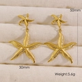 Detalle de pendientes de estrella de mar en oro 14K con textura y medidas de 50 mm - Dorado