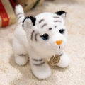 Plush white tiger toy with black stripes and orange nose on a cozy beige rug - White Tiger