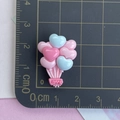 Détail de ballons cœur en résine rose et bleu avec texte LOVE sur tapis gradué - Ballon Rose Clair