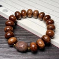 Dark rosewood bracelet featuring a carved barrel bead and golden metal spacers - 15mm Abacus Bead With Carved Date Bead
