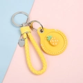 Cartoon pineapple leather key ring for airtag with bright yellow woven strap and metal hook - Hand Strap Style - Pineapple Yellow