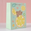 Detail view of a light green starry paper gift bag with cartoon bear and lemon prints - Green Bear - Small / 14x7x15.5cm