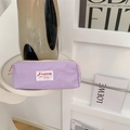 Paars etui op witte plank met moderne vaas en details van modetijdschriften op de foto - Lichtpaars