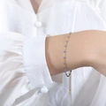 Gold chain bracelet with vibrant blue enamel beads on a woman's wrist - Bracelet / Blue
