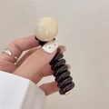 Black spiral telephone wire hair tie with beige pearl accent for ponytail styling - Cream