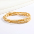 Detail of cream seed bead body chain showing multi-layered elastic wrap texture - Beige