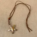 Detailopname van zeester hanger ketting van hars met textuur en bruine lederen koord - Zeestervorm (HN9210)