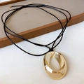 Minimalistische gouden ketting met ovale hanger en zwart koord voor een moderne look - Goud
