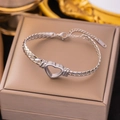 Macro view of silver stainless steel heart bracelet with hollow design on jewelry box - Hollow Heart Bracelet / Steel