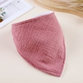 Detailed view of pink double-layer cotton gauze baby bib displayed on a wooden table - Deep Pink
