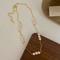 Detailed macro view of gold plated pearl necklace showing lobster clasp and adjustable chain - 15 Pearls Gold Necklace