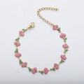 Close-up of DIY cherry bracelet with pink glitter fruits and green enamel leaves details - Gold+Pink