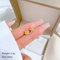 Macro view of 8mm gold snowflake stud earring on fingertip showing size and weight details - Gold Snowflake Style (T217)