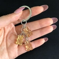 Detail of yellow candy bear resin charms on a silver metal keychain with dark background - Light Yellow