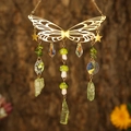 Detail of golden butterfly suncatcher with crystal beads and mushrooms on tree bark - Gold Wings + Peridot