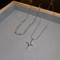 Primo piano di collane a doppio strato con stelle e diamanti su vassoio grigio - Collana a Doppio Strato con Stella d'Argento
