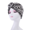 Detail view of bohemian turban hat with black and white geometric print on white mannequin - Style 13-Black White Grey Geometric Pleated