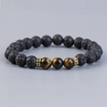 Lava stone and tiger eye beaded bracelet with gold metal spacers on gray background - Yellow Tiger Eye