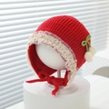 Detail der roten Baby-Strickmütze mit weißer Spitze, grüner Schleife und Bommel - 3-15 Monate / Rot