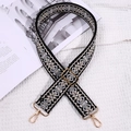 Detail of black ethnic embroidered wide guitar strap with gold lobster clasps on soft fabric - Black